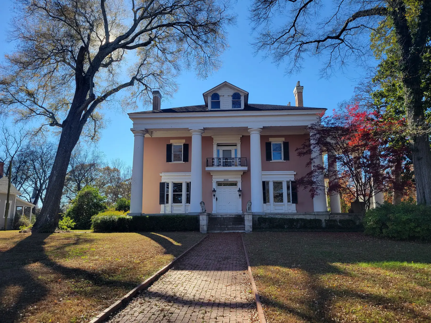 The Archibald Howell home in Marietta, a pale pink house with white columns at the end of a brick walk under old trees