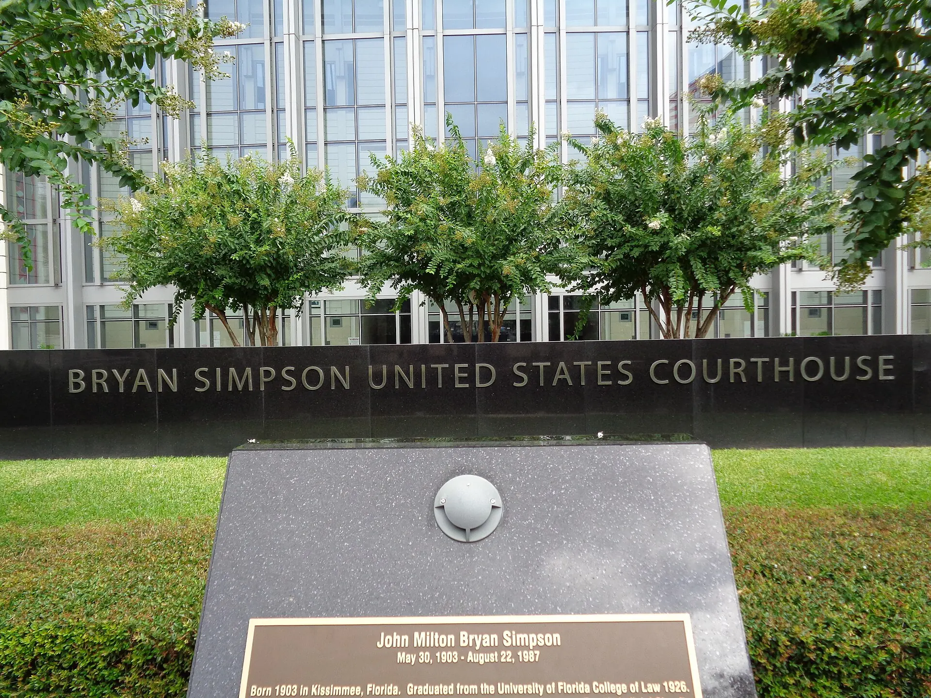 The Bryan Simpson United States Courthouse name wall in Jacksonville, Florida, with the glass tower behind it