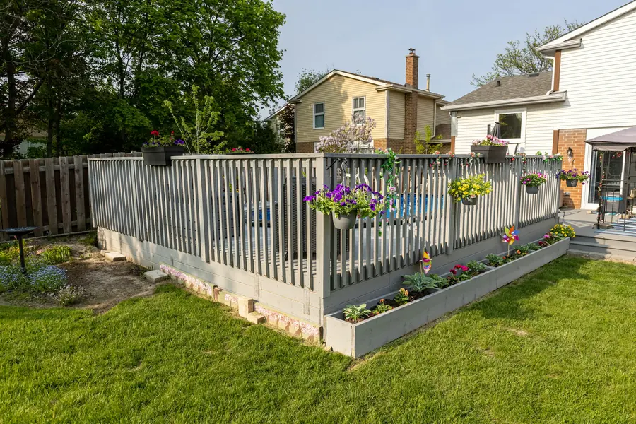 A fence with flower boxes between two neighbors' backyards